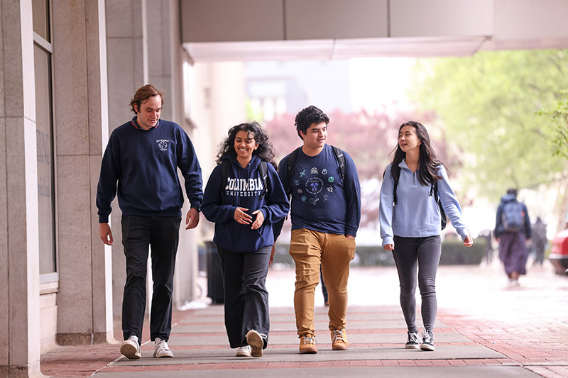 Four students walk together on Columbia University's campus.