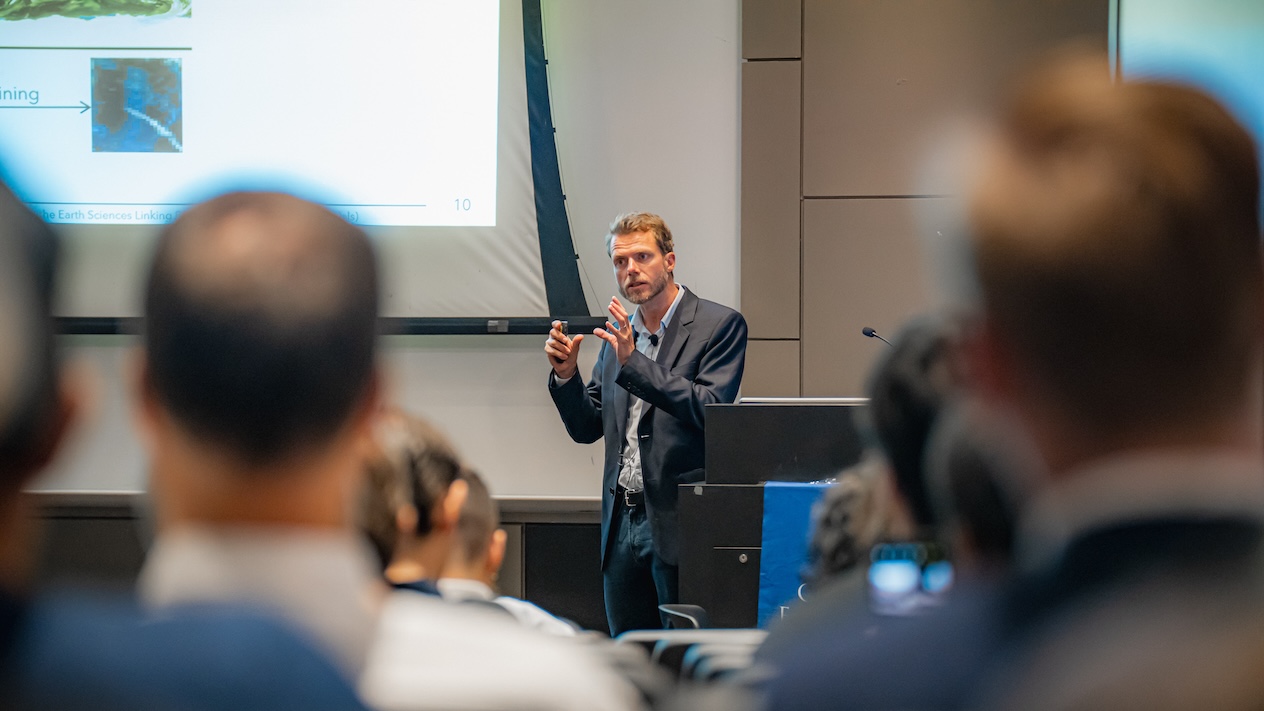 Pierre Gentine presenting in front of a seated crowd