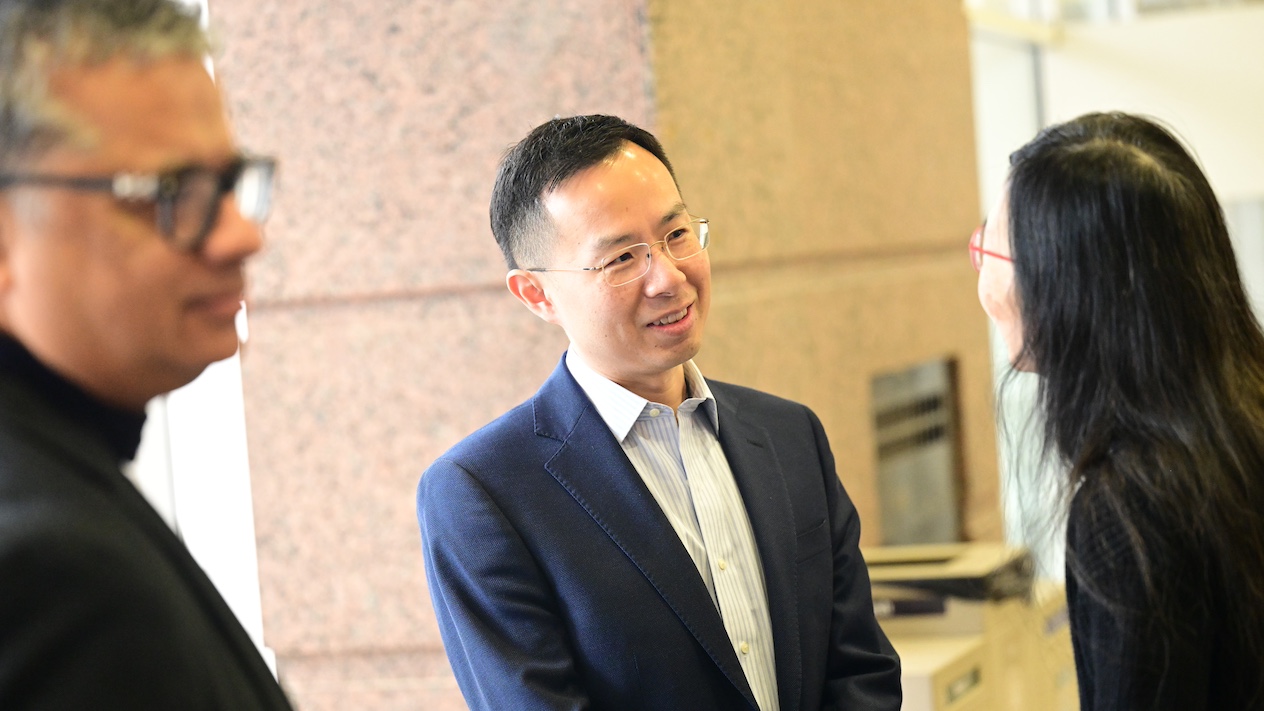 photo of jingren zhou speaking with someone