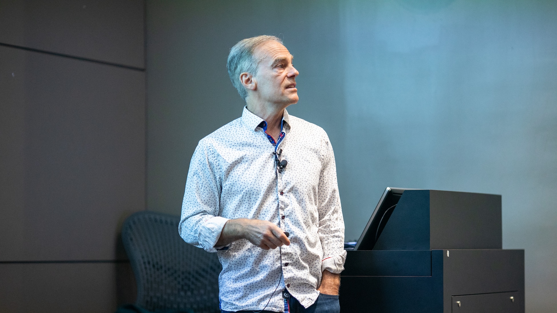 Richard Zemel standing at front of an auditorium, looking toward an audience.