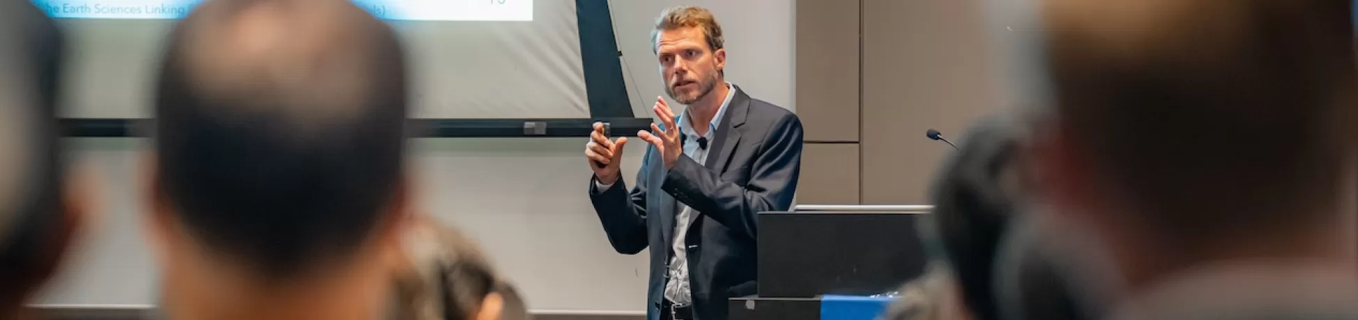 Pierre Gentine presenting in front of a seated crowd