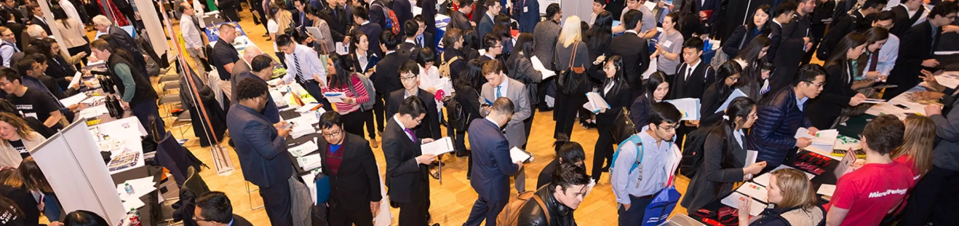 Students in business attire crowd an auditorium for a career fair